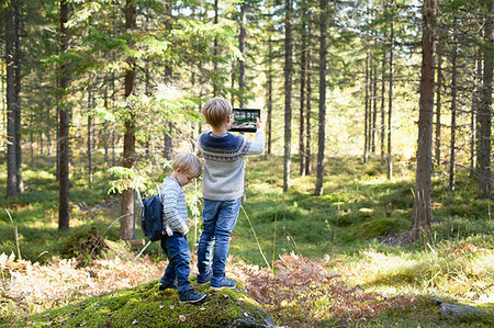 simsearch:649-07596719,k - Toddler with brother taking photograph of forest Fotografie stock - Premium Royalty-Free, Codice: 649-09277397