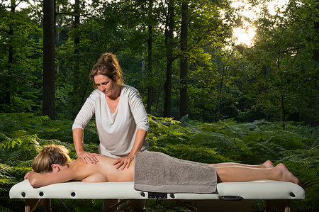 full body massage - Professional masseuse treats woman on massage table in woods Foto de stock - Sin royalties Premium, Código: 649-09277659