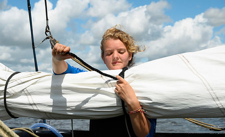 Girl prepares sails on flat-bottom traditional sailing ship, Sneekermeer, Friesland, Netherlands Stock Photo - Premium Royalty-Free, Code: 649-09277665