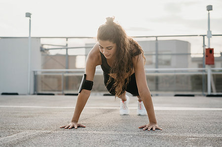 simsearch:693-05552869,k - Young woman doing plank on rooftop deck Stock Photo - Premium Royalty-Free, Code: 649-09277703