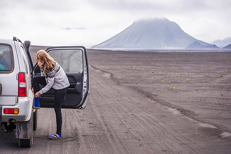 Woman changing shoes by vehicle door on dirt track, Landmannalaugar, Iceland Stock Photo - Premium Royalty-Free, Code: 649-09277834