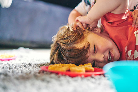 simsearch:649-03667434,k - Boys play-fighting during meal on rug Stock Photo - Premium Royalty-Free, Code: 649-09277901