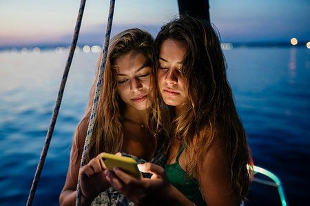 friends sailing - Friends on sailboat, sharing text message, Italy Stock Photo - Premium Royalty-Free, Code: 649-09277992