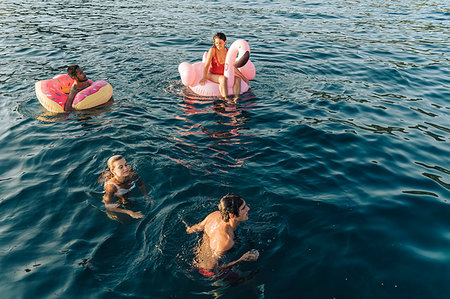 simsearch:649-09278006,k - Friends swimming and relaxing on floats on sea, Italy Stock Photo - Premium Royalty-Free, Code: 649-09278017