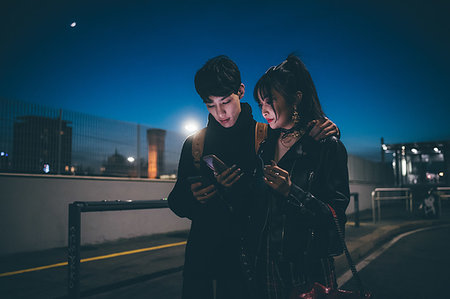 simsearch:649-09278133,k - Young couple sharing text on street, Milan, Italy - Photographie de stock - Premium Libres de Droits, Code: 649-09278173