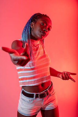 Woman with arm reaching out against red background Foto de stock - Sin royalties Premium, Código: 649-09278270