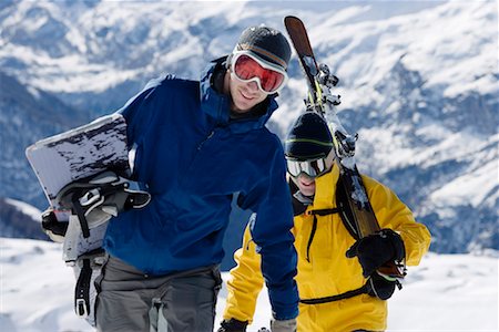 Male skier and male snowboarder walking up mountain ridge carrying skis Stock Photo - Premium Royalty-Free, Code: 649-01556015