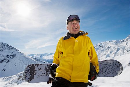 Mature male snowboarder with snowboard on mountain, portrait Stock Photo - Premium Royalty-Free, Code: 649-01556020