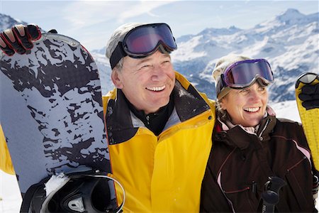 Mature couple in ski-wear holding Skis and snowboard on mountain, close-up, portrait Stock Photo - Premium Royalty-Free, Code: 649-01556023
