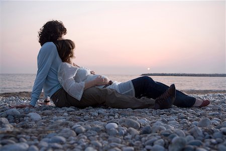 sunset point - Young couple lying on beach, woman pregnant, sunset Foto de stock - Sin royalties Premium, Código: 649-01556421