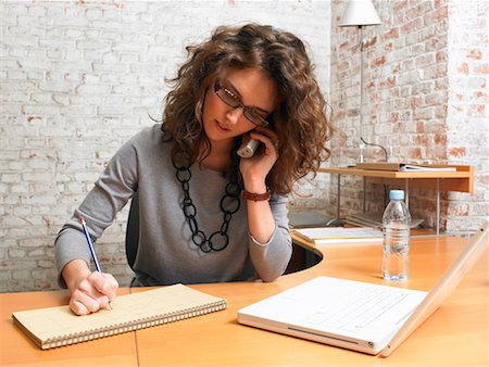 desk with wall - Businesswoman talking on the phone and writing. ,Brussels, Belgium. Stock Photo - Premium Royalty-Free, Code: 649-01556563