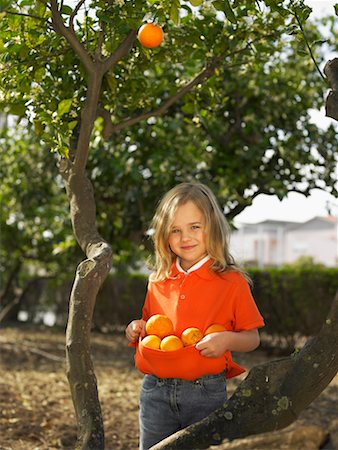 simsearch:649-01556826,k - Portrait of young girl (5-7) holding oranges in front of tree, Alicante, Spain, Stock Photo - Premium Royalty-Free, Code: 649-01556836