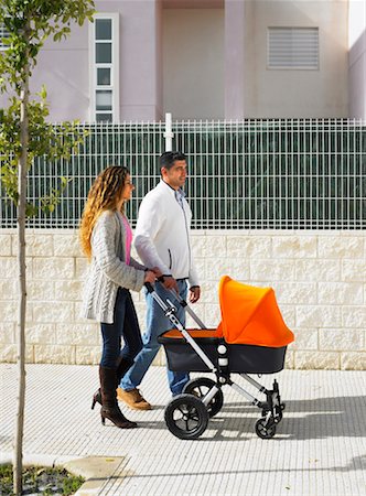 Couple walking with pram on pavement, Alicante, Spain, Stock Photo - Premium Royalty-Free, Code: 649-01556890