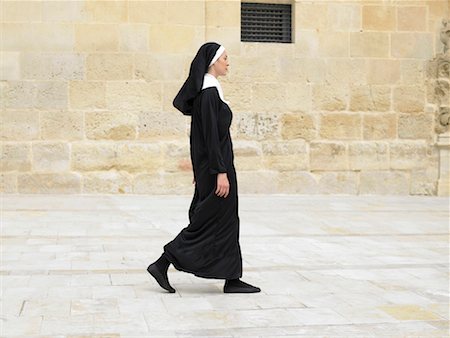 side view nuns walking - Nun walking in front of stone wall, Alicante, Spain, Stock Photo - Premium Royalty-Free, Code: 649-01557026