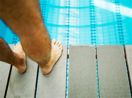 Man standing on diving board, close-up, low section Stock Photo - Premium Royalty-Free, Code: 649-01557799