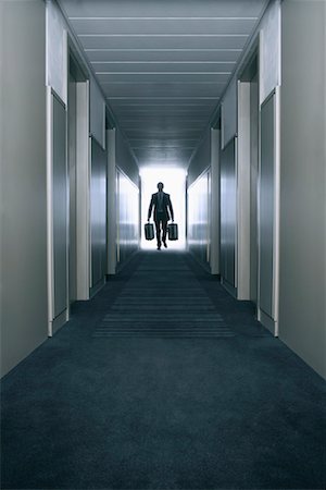 people walking in the distance - Man carrying suitcases in a hallway Stock Photo - Premium Royalty-Free, Code: 649-01608255