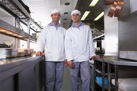 Deux chefs posant dans leur cuisine Photographie de stock - Premium Libres de Droits, Code: 649-01608263