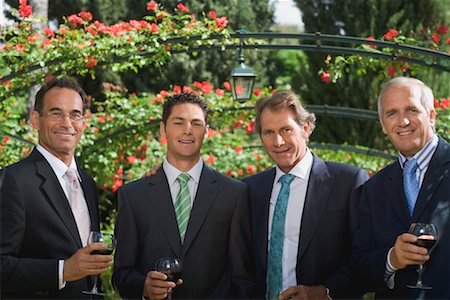 Four businessmen drinking wine in a garden Stock Photo - Premium Royalty-Free, Code: 649-01608499
