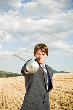 sword - Businessman fencing in wheat field. Stock Photo - Premium Royalty-Free, Code: 649-01608601