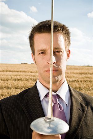 fighting to protect - Businessman fencing in wheat field. Stock Photo - Premium Royalty-Free, Code: 649-01608603