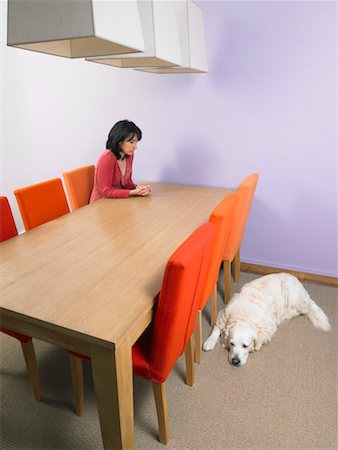 Businesswoman waiting at meeting table with dog  sleeping on floor. Stock Photo - Premium Royalty-Free, Code: 649-01608802