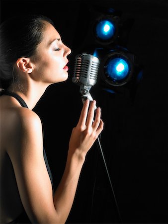 estrella (mujer) - Woman singing into microphone. Foto de stock - Sin royalties Premium, Código: 649-01608914