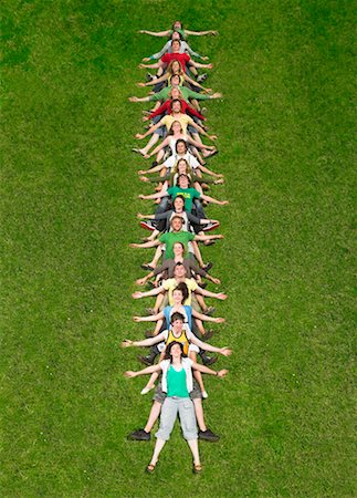 Group lying back on each other in a line on grass Stock Photo - Premium Royalty-Free, Code: 649-01609547