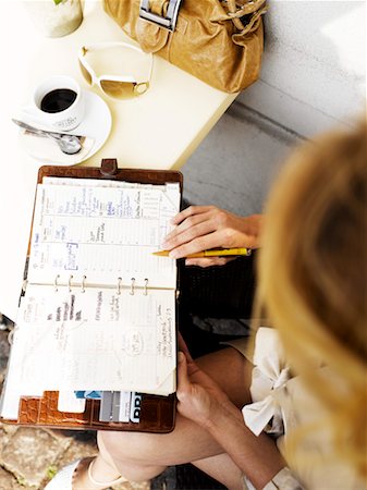 restaurant furniture in europe - Woman at an outdoor restaurant with her day planner Stock Photo - Premium Royalty-Free, Code: 649-01610530