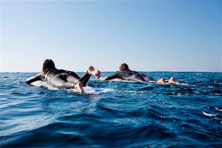 Couple going out on surfboards in the water. Stock Photo - Premium Royalty-Free, Code: 649-01695886