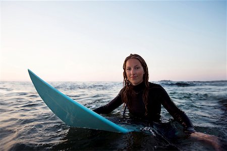 simsearch:649-08307256,k - Woman sitting on surfboard in the water. Fotografie stock - Premium Royalty-Free, Codice: 649-01696037