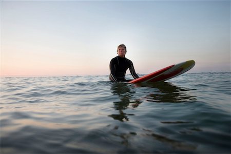 simsearch:649-01695983,k - Man sitting on surfboard in the water. Fotografie stock - Premium Royalty-Free, Codice: 649-01696041