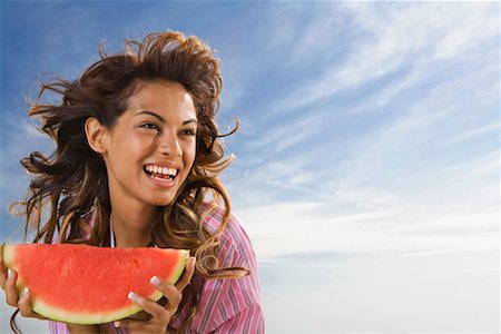 Woman laughing and eating watermelon outdoors. Stock Photo - Premium Royalty-Free, Code: 649-01696324