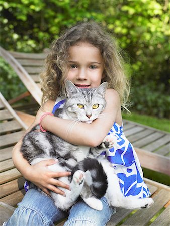 picture of cat sitting on plant - Young girl outdoors smiling with a cat on her lap. Stock Photo - Premium Royalty-Free, Code: 649-01696460