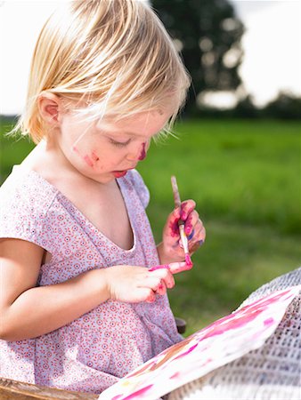 Little girl painting in a green field. Stock Photo - Premium Royalty-Free, Code: 649-01754184