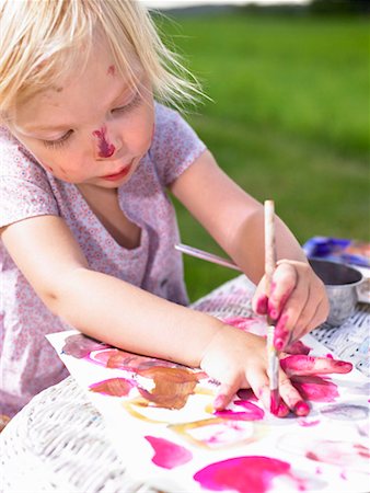 Little girl painting in a green field. Stock Photo - Premium Royalty-Free, Code: 649-01754185