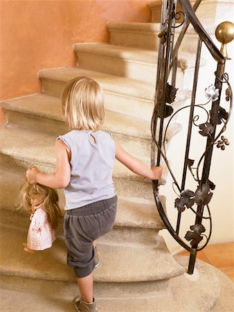 simsearch:632-05554100,k - Little girl climbing up the stairs. Foto de stock - Royalty Free Premium, Número: 649-01754284