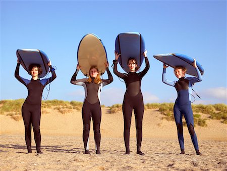 Four female surfers standing on a beach. Stock Photo - Premium Royalty-Free, Code: 649-01754928