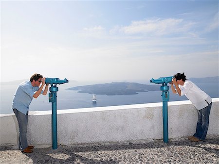 santorini island greece and people - Couple looking through spyglasses Stock Photo - Premium Royalty-Free, Code: 649-02054221