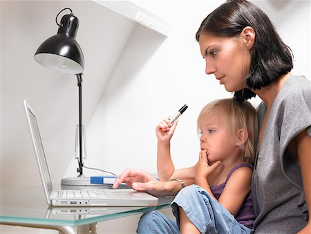 Mother and daughter looking at a laptop Stock Photo - Premium Royalty-Free, Code: 649-02054349