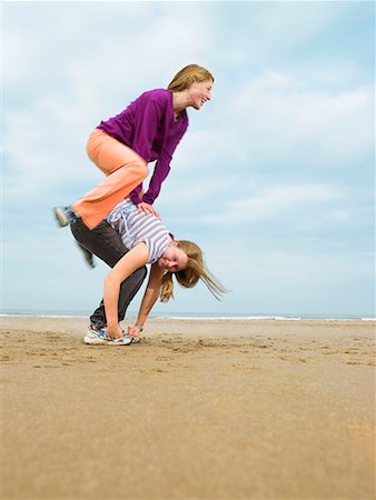 Two females playing leap-frog on beach Stock Photo - Premium Royalty-Free, Code: 649-02054510