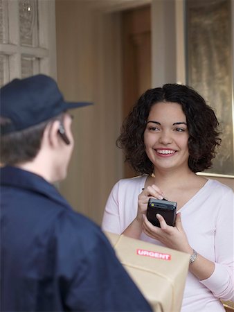 signing (signature) - Woman signing for package with courier Stock Photo - Premium Royalty-Free, Code: 649-02055142