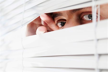 Homme regardant à travers les stores Bureau Photographie de stock - Premium Libres de Droits, Code: 649-02055353