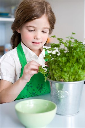 smelling food children - Girl pulling herbs Stock Photo - Premium Royalty-Free, Code: 649-02053923