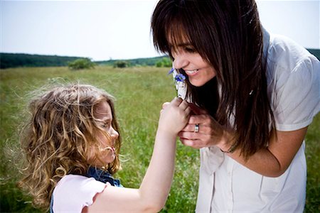 family playing outdoors parent ethnic not beach not park - Woman smelling flower with daughter Stock Photo - Premium Royalty-Free, Code: 649-02198861