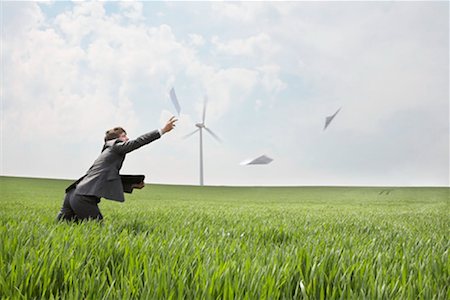 paper airplane - Businessman chasing papers on wind farm Stock Photo - Premium Royalty-Free, Code: 649-02199600