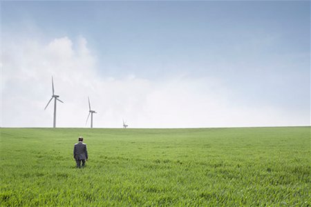 Man walking towards wind turbines Stock Photo - Premium Royalty-Free, Code: 649-02199601