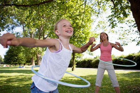 Mother and daughter with hula-hoop Foto de stock - Royalty Free Premium, Número: 649-02199659