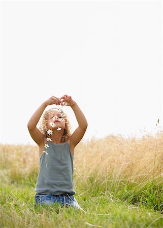 Young girl making a daisy chain in field Fotografie stock - Premium Royalty-Free, Codice: 649-02424004