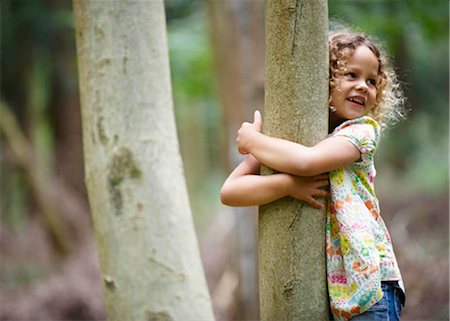 Young girl hugging tree smiling Fotografie stock - Premium Royalty-Free, Codice: 649-02424024