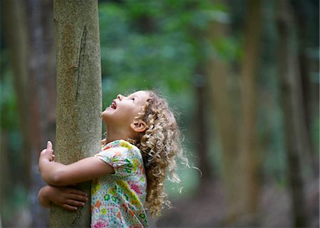 Young girl hugging tree looking up Fotografie stock - Premium Royalty-Free, Codice: 649-02424025